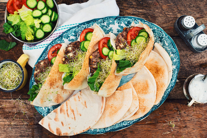patties in pita breads, vegetables