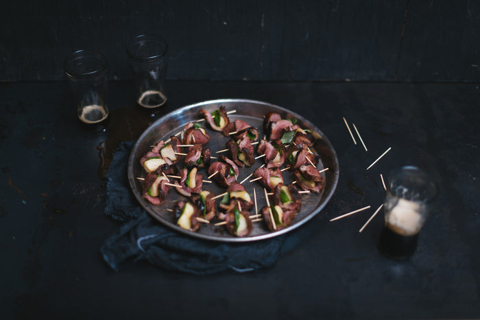 duck bites with apple slices and basil leaves